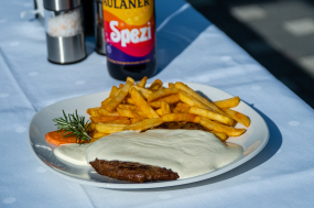 Pleskavica mit Kartoffelscheiben und Kajmak