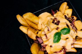 Frytki z sosem serowym i siekanym bekonem