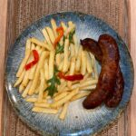 Cârnați proaspeți la tigaie cu cartofi pai