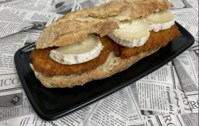 Bocadillo de pollo empanado, lechuga con queso de cabra y salsa merit.