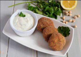 Cuatro piezas de falafel con salsa de yogurt.