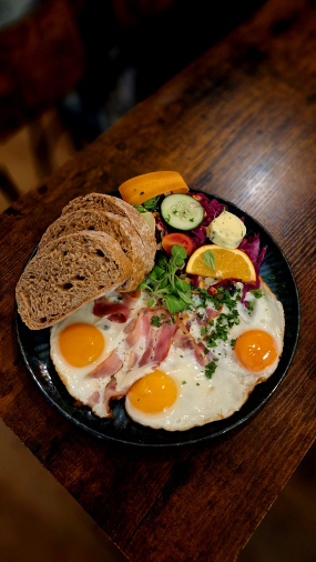 Čtyři sázená vejce s opečenou slaninou a farmářským chlebem