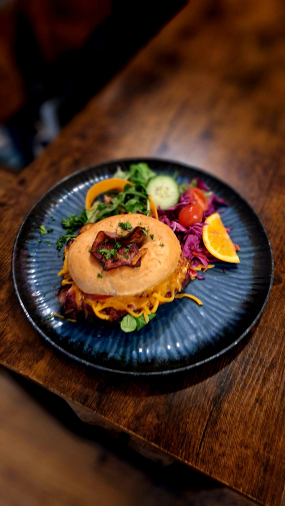 Americký bagel plněný sázeným vejcem, slaninou, sýrem cheddar a rajčetem