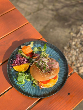 Americký bagel plněný sázeným vejcem, slaninou, sýrem cheddar a rajčetem 