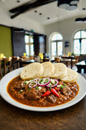 5) Hovězí guláš podávaný s houskovým knedlíkem 