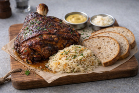 13) Vepřové koleno nakládané v pivní marinádě pomalu pečené,  podávané se zelím, hořčicí, křenem a chlebem 