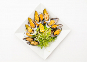 Małże Nowozelandzkie na połówce muszli.