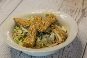 Szezámmagos rántott csirkemell csíkok kevert saláta ágyon